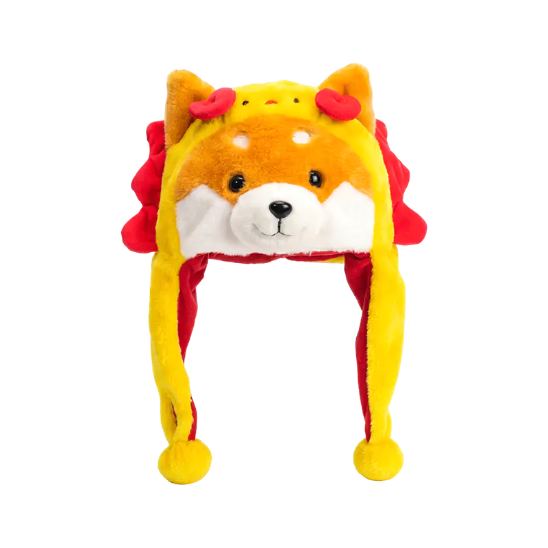 Żółta shiba z pluszową czapką z czerwoną grzywą